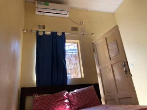 a bedroom with a bed with a blue curtain and a window at Residencial Meu Tio in Chimoio