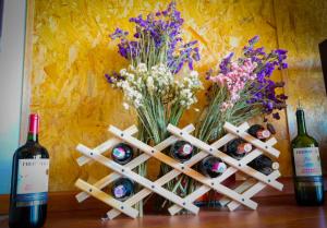 un montón de botellas de vino y un jarrón de flores en Meraki_Paipa, en Paipa