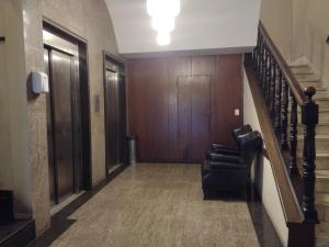 a hallway with a staircase and a chair in a building at Lux Hotel in São Paulo