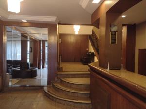 a lobby with stairs in a building with a mirror at Lux Hotel in Sao Paulo