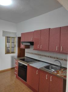 a kitchen with red cabinets and a sink at Casa Celeste San Isidro in San Isidro