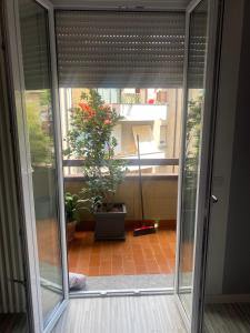 uma porta aberta para uma varanda com uma planta em the AllSun em Tirano