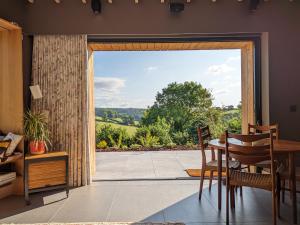 jadalnia z dużymi przesuwnymi szklanymi drzwiami w obiekcie Nuthatch Retreat - Modern rustic ecohome with views w mieście Blakeney