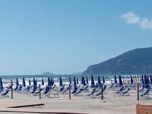 - un groupe de chaises longues et de parasols sur une plage dans l'établissement Appartamento Il Castagno, à Fosdinovo