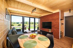 a room with a table and a couch and a television at Baza Dunajec Komfortowy Domek in Czarny Dunajec