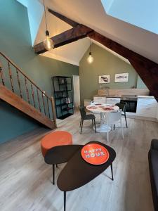 a living room with a table and chairs and a kitchen at duplex refait à neuf in Boulogne-sur-Mer