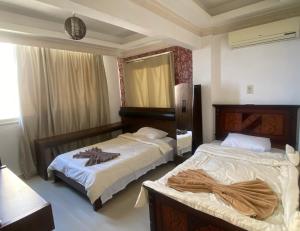 1 dormitorio con 2 camas y espejo en Luxury apartments in sanstefano en Alexandría