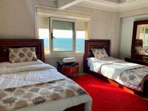 a bedroom with two beds and a view of the ocean at Luxury apartments in sanstefano in Alexandria