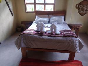 two stuffed animals sitting on top of a bed at Salkantay Hostel Chaullay in Santa Teresa