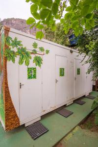 a row of white garage doors with green windows at Auá Hostel in Petrópolis