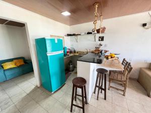 a kitchen with a refrigerator and a table and chairs at Verano House BF in Baía Formosa