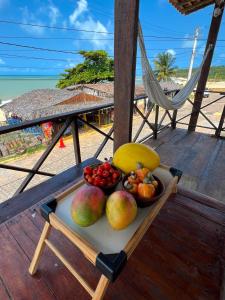 a tray of fruit on a table on a beach at Verano House BF in Baía Formosa