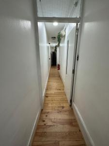 a hallway with a wooden floor and white walls at Notting Hill Guest Studio in Ealing
