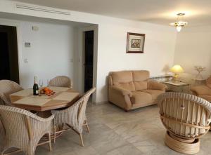 a living room with a couch and a table and chairs at Panorama3 in Altea la Vieja