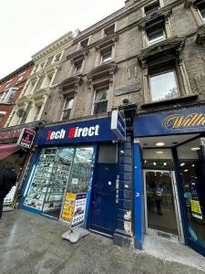 een winkel met een blauw bord aan de zijkant van een gebouw bij Notting Hill Guest Studio in Ealing