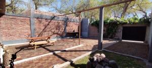 eine Terrasse mit einer Bank und einem Gebäude in der Unterkunft Casa Céntrica para 7 personas Estacionamiento Gratuito in Mendoza
