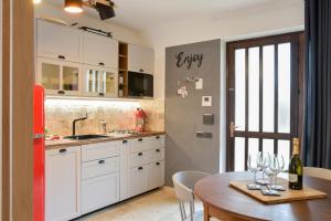 a kitchen with white cabinets and a table with wine glasses at Rock Garden Apartment in Arco