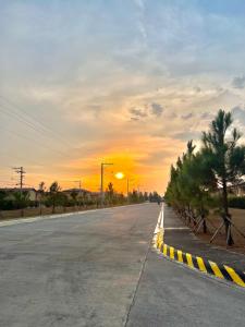an empty road with a sunset in the background at Two-Bedroom Townhouse Camella Bacolod South in Bacolod