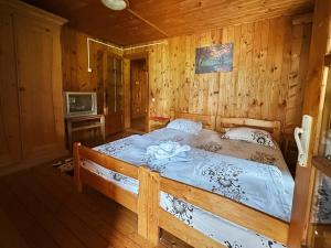 una camera da letto con letto in una camera in legno di Rustic House a Bran
