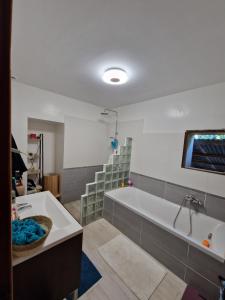 a large bathroom with a tub and a sink at La ferme des Demoiselles in Sarrians