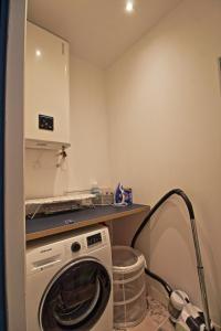a kitchen with a washing machine in a room at Le Sensas - Climatisation et Centre in Nîmes