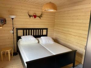 a bedroom with a bed in a wooden wall at Villa Aitti in Utsjoki