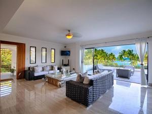 a living room with couches and a view of the ocean at RIBERAMAR Las Terrenas, Samana in Las Terrenas