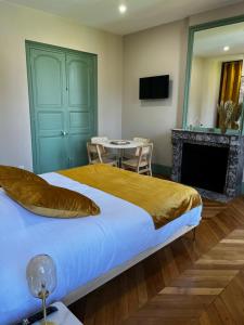um quarto com uma cama com lareira e uma mesa em La Parenthèse Fléchoise, Chambre Armand em La Flèche