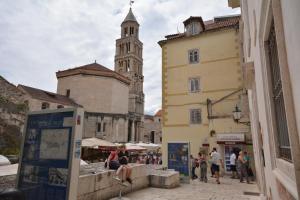 a group of people walking down a street with a clock tower at Apartments Kaleta in Split