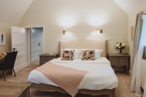 a bedroom with a large white bed with two dogs pillows at Laundry Cottage in Loughborough