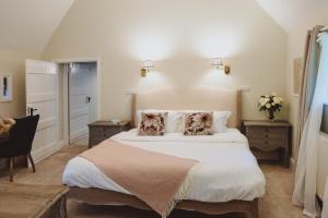 una camera da letto con un grande letto bianco con due cuscini a forma di cane di Laundry Cottage a Loughborough