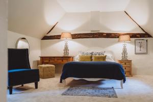 um quarto com uma cama e uma cadeira em Laundry Cottage em Loughborough