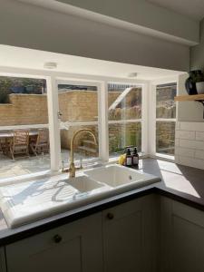 a kitchen with a sink and some windows at Holly Bank in Longborough