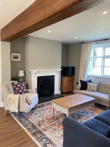 a living room with a couch and a fireplace at Holly Bank in Longborough
