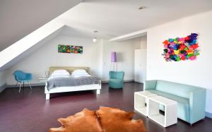 sypialnia na poddaszu z łóżkiem i kanapą w obiekcie Stanys - Das Apartmenthotel w Wiedniu