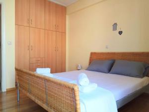 una camera da letto con letto, lenzuola bianche e armadi in legno di Angela's Home (Near Athens Airport) a Spata