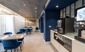 a restaurant with blue walls and tables and blue chairs at AMMA Lisboa Hotel in Lisbon