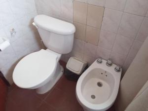 uma casa de banho com um WC branco e um bidé em La Mima em Capilla del Monte