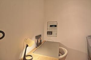 un escritorio con una lámpara y una foto en la pared en Le Sensas - Climatisation et Centre, en Nimes