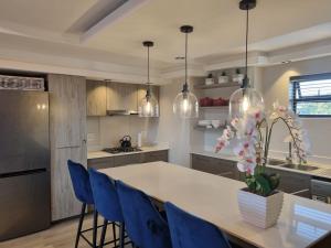 a kitchen with a table and blue chairs at Soho Luxury Penthouse in Sandton