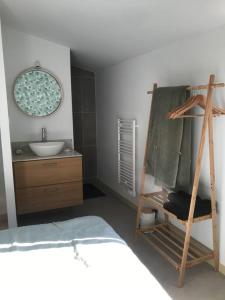 uma casa de banho com um lavatório e uma escada ao lado de uma cama em Maison du Saleys em Salies-de-Béarn