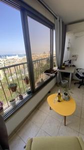 a living room with a table and large windows at Sea view apartment in Haifa
