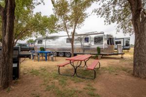 a campsite with a picnic table and a trailer at Big Texan Airstream in Amarillo