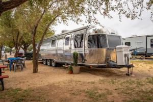 an old rv parked in a park next to a table at Big Texan Airstream in Amarillo