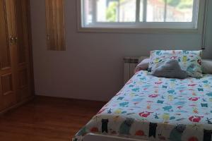 um quarto com uma cama com um bicho de peluche em Tranquilidad y Naturaleza em Mondariz-Balneario