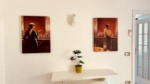 three paintings hanging on a wall in a room at Appartamento Maison Marì in Termini