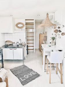 - une cuisine avec des placards blancs, une table et un évier dans l'établissement ELSK Cottage, à Zandvoort