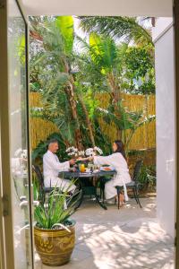 um homem e uma mulher sentados à mesa com comida em The Cape Bali em Cidade do Cabo