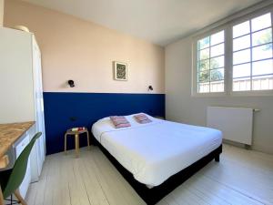 Un dormitorio con una cama grande y una ventana en Agréable villa à Pyla plage en La Teste-de-Buch