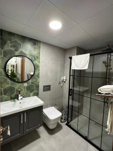 uma casa de banho com um lavatório, um WC e um espelho. em Marista Pansiyon em Istambul
